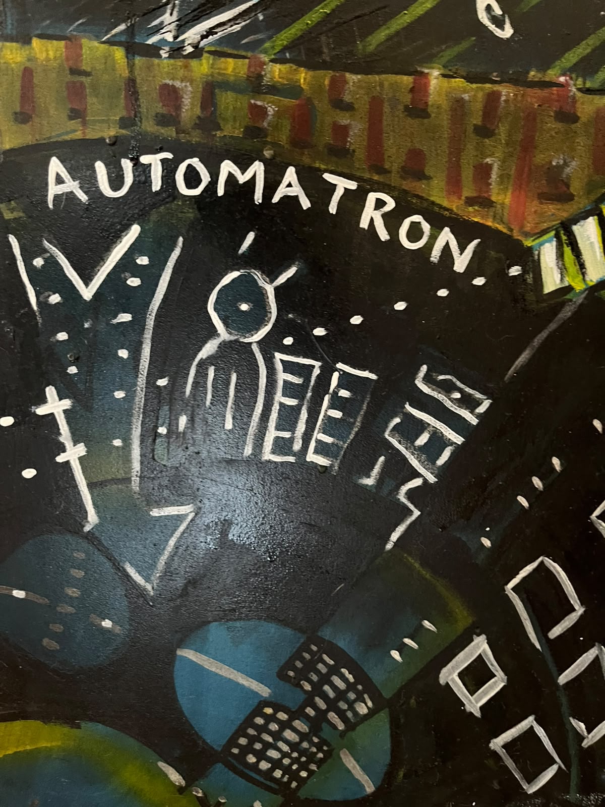 Detail — figure beneath the word Automatron